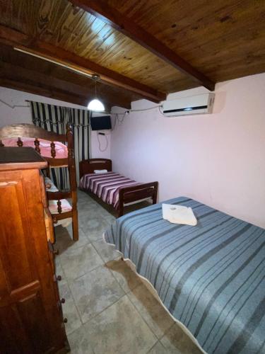 ein Schlafzimmer mit 2 Betten und einem Schreibtisch. in der Unterkunft Cabañas los álamos in Termas de Río Hondo