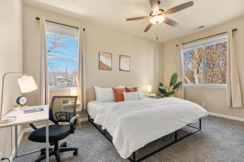 a bedroom with a bed and a desk and a ceiling fan at MidTown Hideaway Fire Pit and King Beds in Reno