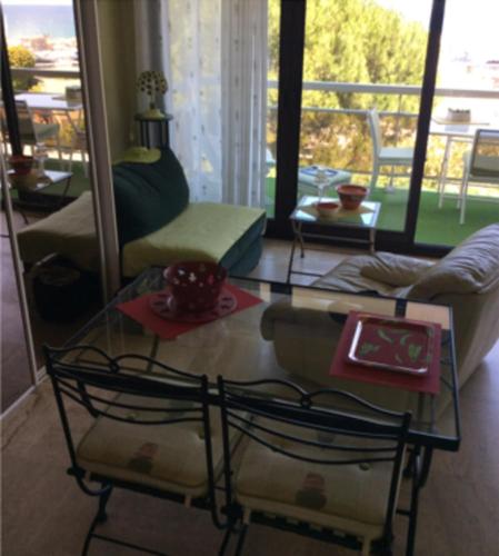uma sala de estar com duas cadeiras e uma mesa de vidro em Lovely T2 with garden - near the beach em Cannes