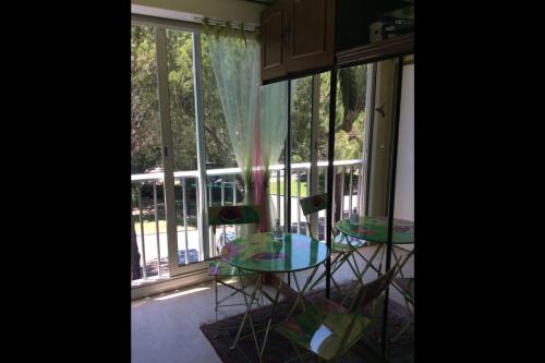 um quarto com uma mesa e cadeiras em frente a uma janela em Lovely T2 with garden - near the beach em Cannes