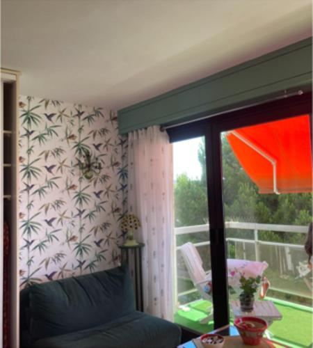 uma sala de estar com um sofá e uma janela em Lovely T2 with garden - near the beach em Cannes