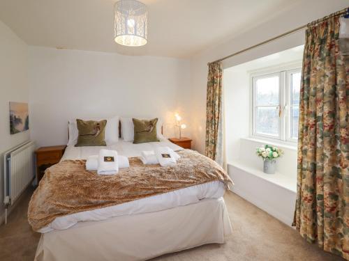 ein Schlafzimmer mit einem Bett mit zwei Handtüchern darauf in der Unterkunft Mill Cottage in Hope