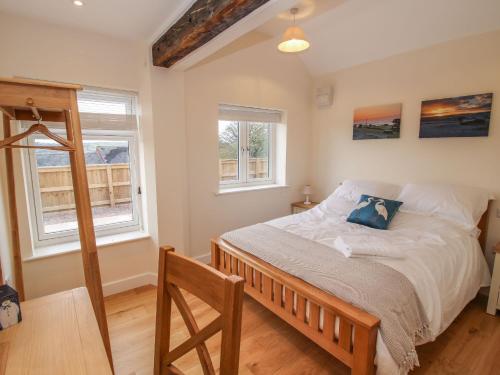 a bedroom with a bed and two windows at Border View Lodge in Welshpool