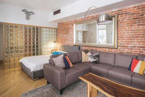 a living room with a couch and a brick wall at MTLVacationRentals - The City Chalet in Montréal