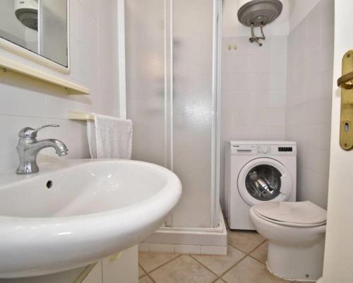 uma casa de banho com um lavatório e uma máquina de lavar roupa em Le residenze Itaca em Porto Pozzo