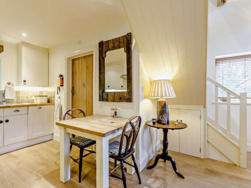 een keuken met een tafel en stoelen en een spiegel bij 1 bed in Stow-on-the-Wold 52145 in Naunton