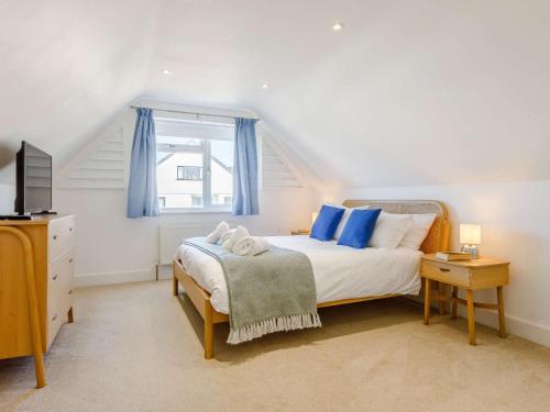a bedroom with a bed with blue pillows and a window at 3 Bed in Bude 87256 in Bude