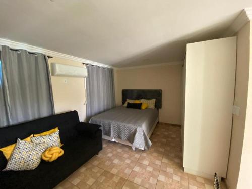 ein Wohnzimmer mit einem Sofa und einem Bett in der Unterkunft Casa temporada in Búzios