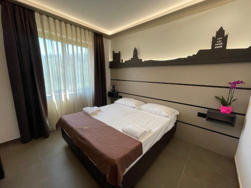 sypialnia z łóżkiem i dużym oknem w obiekcie Palace Hotel Due Ponti w Sienie