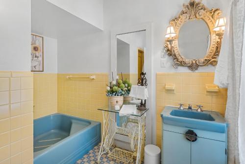 a bathroom with a blue tub and a sink at Grand Mansion-Magnolia suite! in Fort Smith