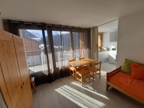 un salon avec une table et un canapé dans l'établissement Studio skis aux pieds proche centre, balcon, parking, animaux admis - FR-1-514-33, à Courchevel