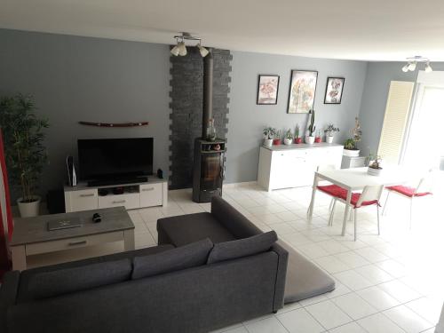 un salon avec un canapé et une table dans l'établissement Maison Piscine et Jardin - Bethisy st Martin(Oise), à Béthisy-Saint-Martin