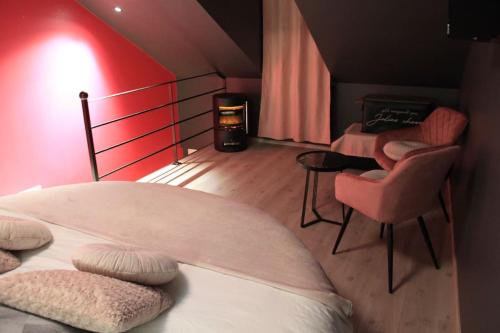 a bedroom with a bed and a table and chairs at L'Ecrin duplex balnéo & Sauna in Troyes