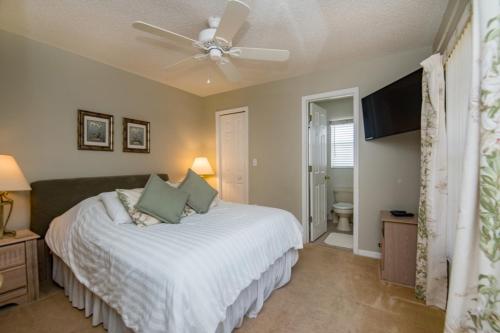 1 dormitorio con cama blanca y ventilador de techo en Executive sth facing,lake view 4 bed 3 bath Near disney, resturants and shopping, en Davenport