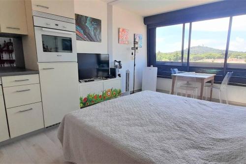 une chambre avec un grand lit et une grande fenêtre dans l'établissement Studio 320, Port Vénus au Village naturiste, au Cap d'Agde