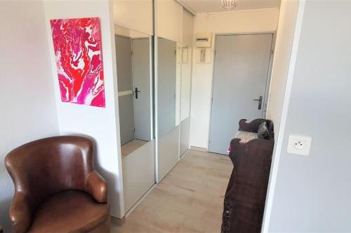 un salon avec une chaise et un miroir dans l'établissement Studio 320, Port Vénus au Village naturiste, au Cap d'Agde
