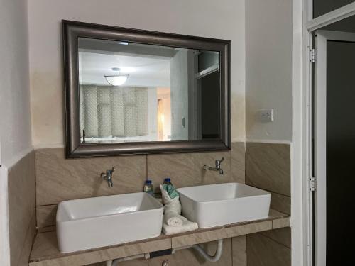 baño con 2 lavabos y espejo grande en Casa Pacific Blue Hawaii, en Chiquimulilla