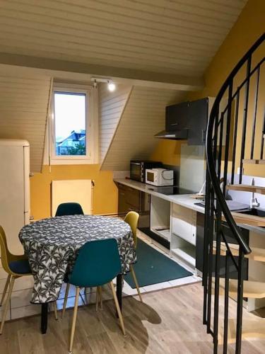 une petite cuisine avec une table et des chaises dans une pièce dans l'établissement Séjour au coeur des Pyrénées, à Bagnères-de-Bigorre