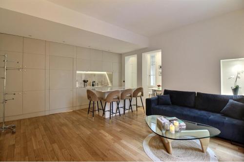 un salon avec un canapé bleu et une table dans l'établissement APPARTEMENT PARIS - LOUVRE & RIVOLI, à Paris