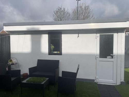 awning over a patio with chairs and a table at Beautiful place to live near Heathrow Windsor Legoland & Free Parking Onsite in Burnham