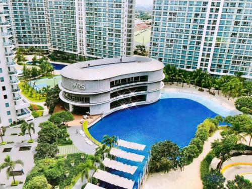 a building with a pool in front of tall buildings at Azure staycation by jane in Manila