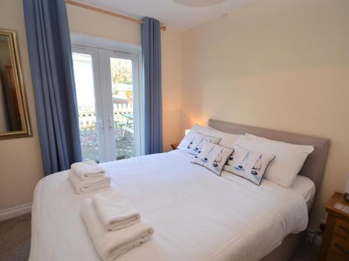 a bedroom with a white bed with towels on it at 2 Bed in Brixham BX081 in Brixham