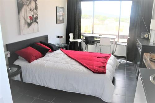 une chambre avec un grand lit avec des oreillers rouges dans l'établissement Studio 315, Port Vénus au village naturiste, au Cap d'Agde