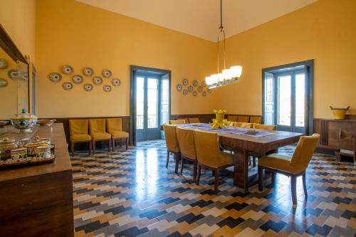 a dining room with a large wooden table and chairs at Case di Cutalia - Villa Cutalia in Camemi