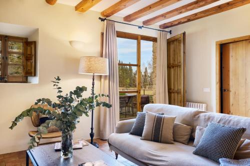 ein Wohnzimmer mit einem Sofa und einem Tisch in der Unterkunft Turismo Rural Mas Ametller in Fontclara