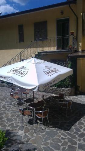 a large white umbrella sitting in front of a building at Hotel Ristorante El Caracol in Mulazzo