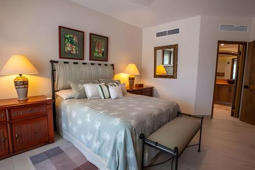 a bedroom with a bed and two lamps and a mirror at Grand Marina Villas in Nuevo Vallarta 