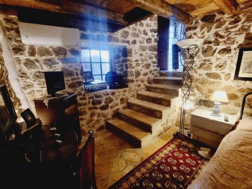a room with a stone wall and stairs in a house at Βίλα Ελιά Παραδοσιάκο σπίτι στην Αμφίκλεια in Amfiklia