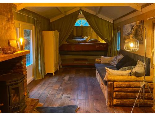 Zimmer mit einem Zelt mit einem Sofa und einem Bett in der Unterkunft Gestrande Woonark in Erica