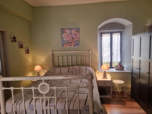 a bedroom with a bed and a table and a window at Βίλα Ελιά Παραδοσιάκο σπίτι στην Αμφίκλεια in Amfiklia