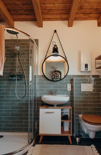 a bathroom with a shower and a sink and a mirror at vandra-eisenach - Ferienhaus mit Garten & Terrasse in Eisenach