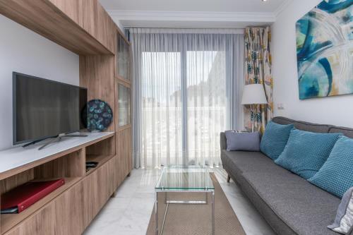 salon z kanapą i telewizorem w obiekcie Cozy apartment perfect for couples SmartTv+WiFi w mieście Fuengirola