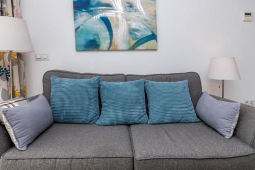 kanapę z niebieskimi poduszkami w salonie w obiekcie Cozy apartment perfect for couples SmartTv+WiFi w mieście Fuengirola