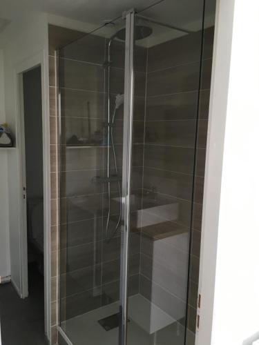 une douche avec une porte vitrée dans une salle de bain dans l'établissement Beautiful and bright 1st Floor Flat with large Terrace - Biarritz City Center, à Biarritz