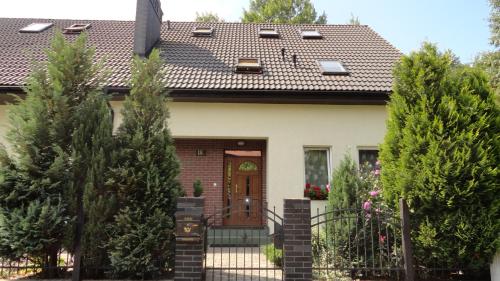 a house with a brown door and trees at Dom Artusa in Ustka
