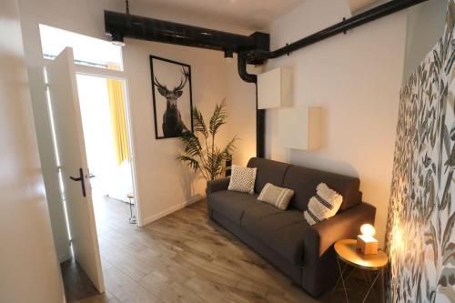 a living room with a couch and a table at Cocon moderne - A deux pas de Bercy in Paris