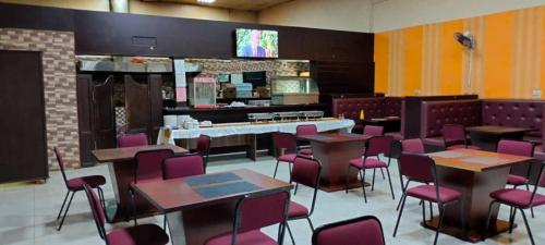 a restaurant with purple chairs and tables and a counter at Luckyone Hotel in Lilongwe