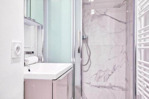 a white bathroom with a shower and a sink at Quiet apartment near Saint-Lazarre - 10P in Paris