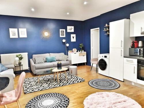 un salon avec un canapé et un mur bleu dans l'établissement Quiet apartment near Saint-Lazarre - 10P, à Paris
