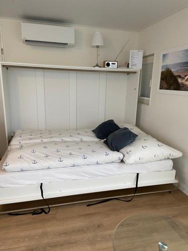 Cama en habitación con marco de cama blanco en Hausboot Claudia Maasbommel, en Maasbommel