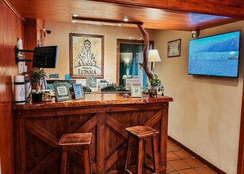 um bar num restaurante com dois bancos de madeira em Lupama em El Calafate