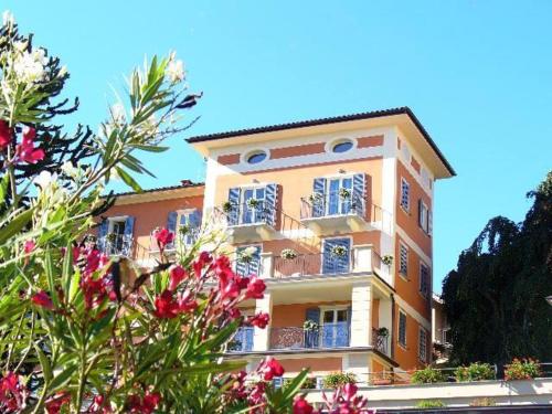 a tall building with flowers in front of it at Hotel Residence La Luna Nel Porto in Stresa