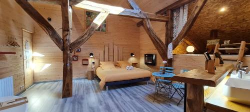 Maison d'hôtes et SPA La Boucotte في Vellerot-lès-Vercel: غرفة نوم بسرير في غرفة بجدران خشبية