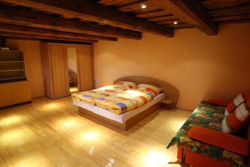 ein Schlafzimmer mit einem Bett in einem Zimmer mit Holzböden in der Unterkunft Apartmany Kanianka in Bojnice