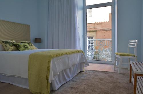 a bedroom with a bed and a view of a balcony at APARTAMENTOS ALMEIDA GARRETT in Ponta Delgada