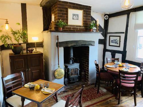 a living room with a fireplace and a table and chairs at The Swan Inn in Midhurst